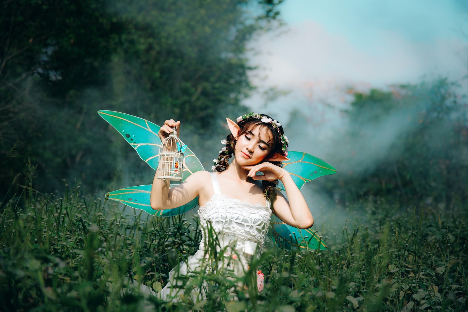 Photo by Anthony Tran woman in white dress wearing green fairy wings